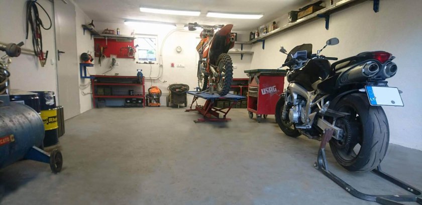 Ремонтирует мотоцикл