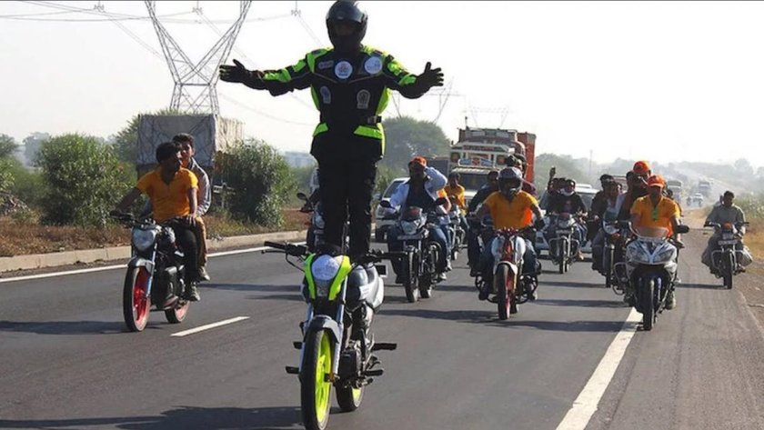 Стоя на сидении мотоцикла