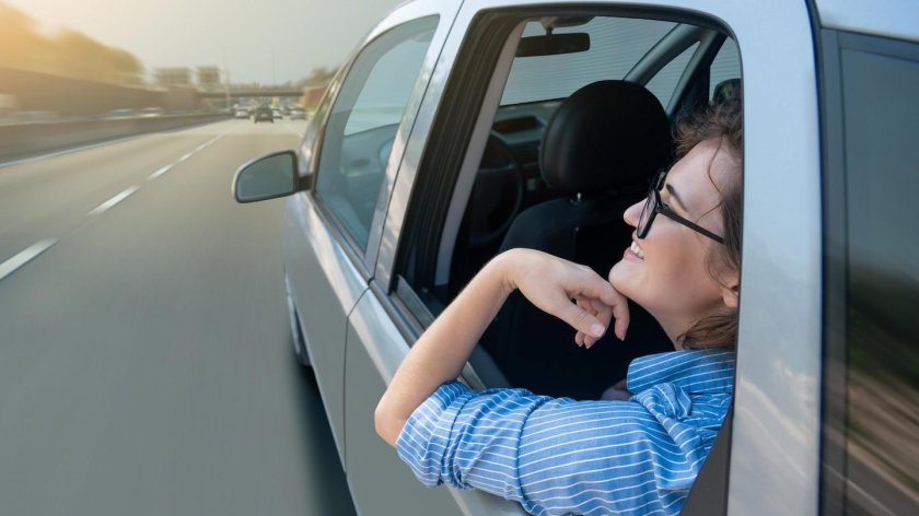 Выглядывает из окна машины