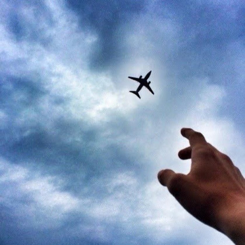 Рука и самолет в небе