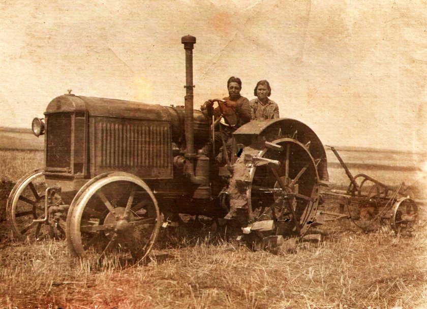 Трактор СТЗ-15 буксирует прицепной комбайн