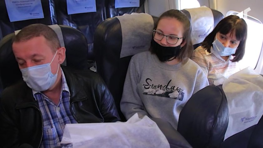 Девушка в маске в самолете