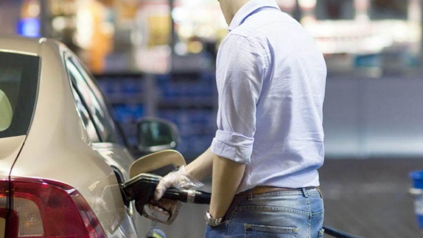 Человек заправляет машину