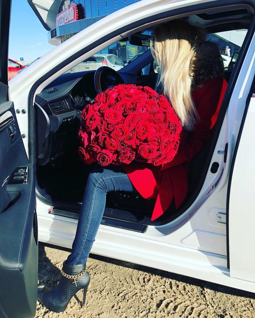 Блондинка с цветами в машине