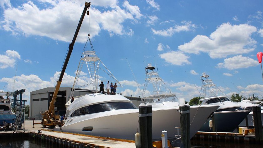 Яхту спускают на воду по наклонным стапелям