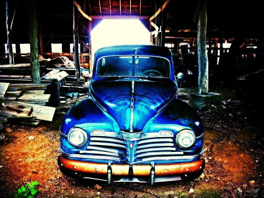 Старая машина с тремя фарами и плавником