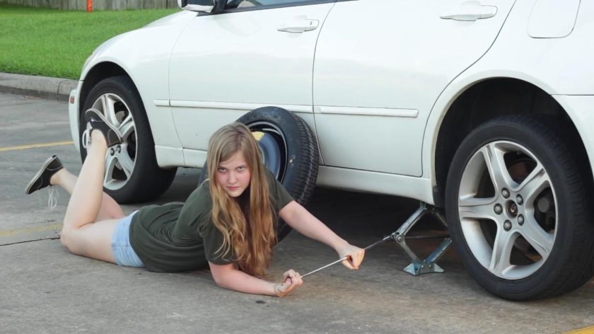 Девушка меняет колесо