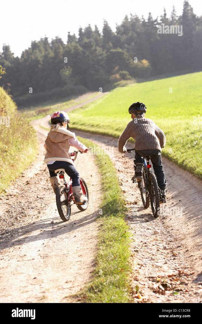Едет на велосипеде в парке