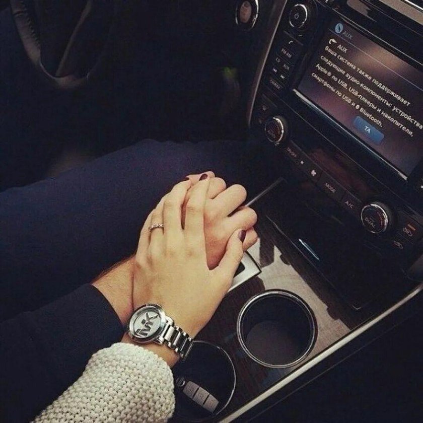 Руки парня и девушки в машине
