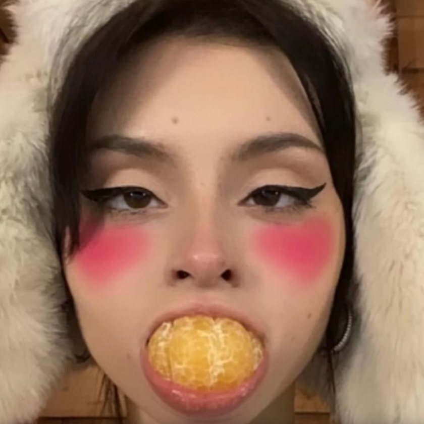 Дора с мандарином во рту