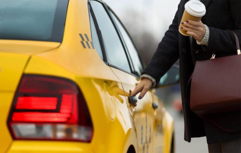 Водитель открывает дверь такси