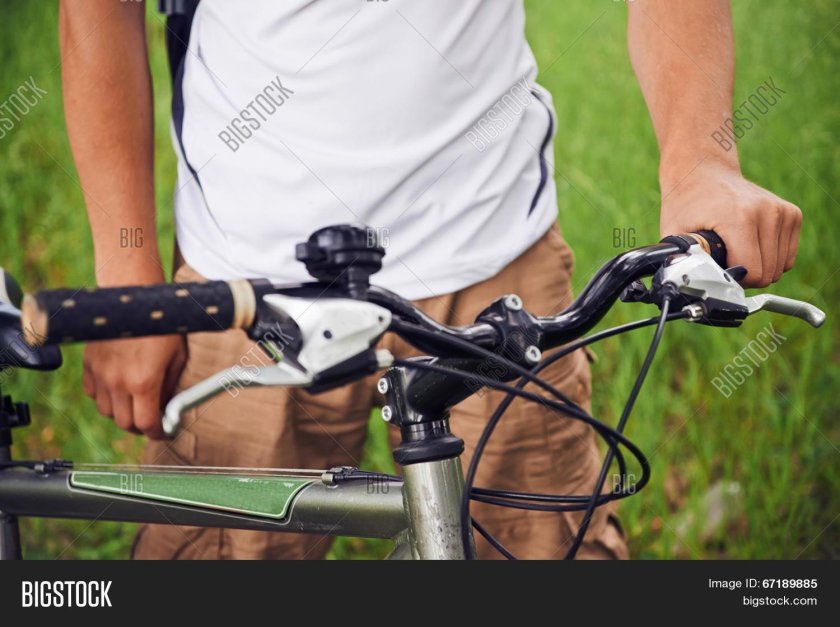 Рука держит руль велосипеда