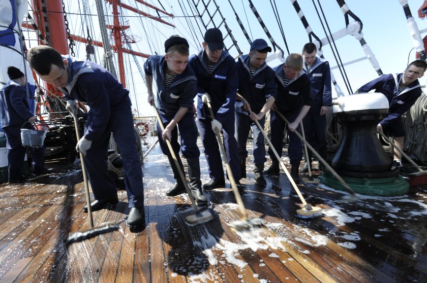 Матрос драит палубу