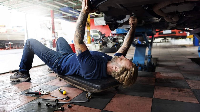 Чинит машину