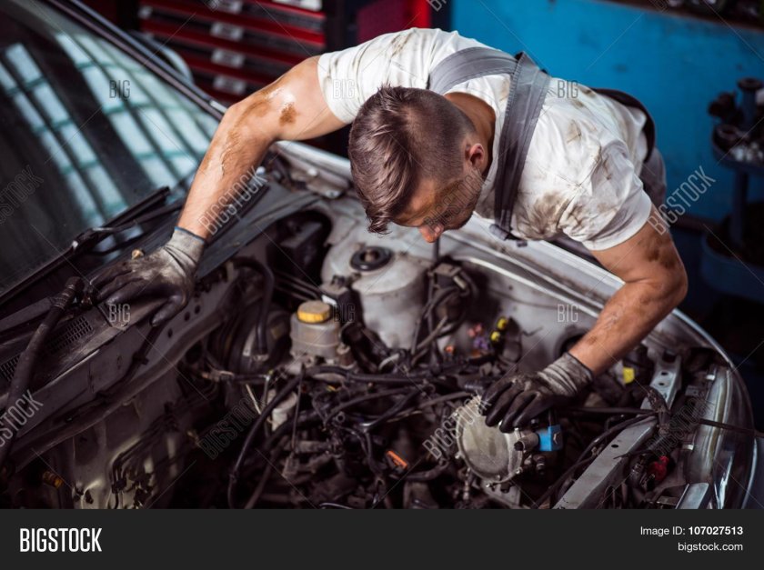 Человек чинит машину