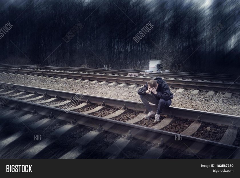 Человек сидит на рельсах