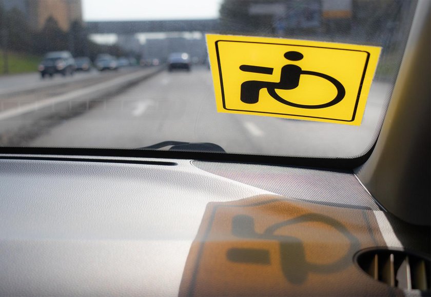 Наклейка инвалидности в машинах на лобовом стекле