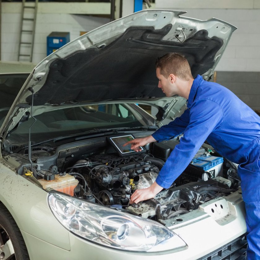 Автомеханик чинит машину