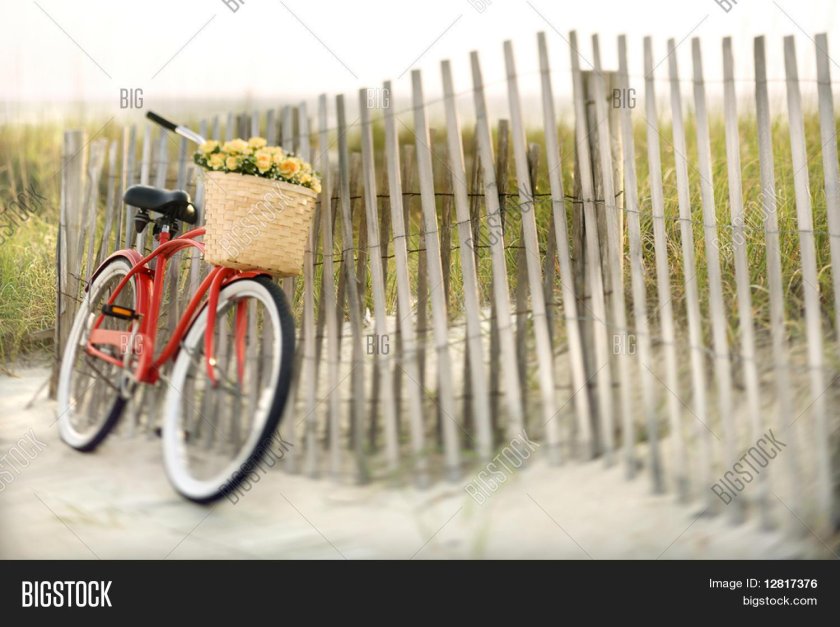 Красный велосипед у забора