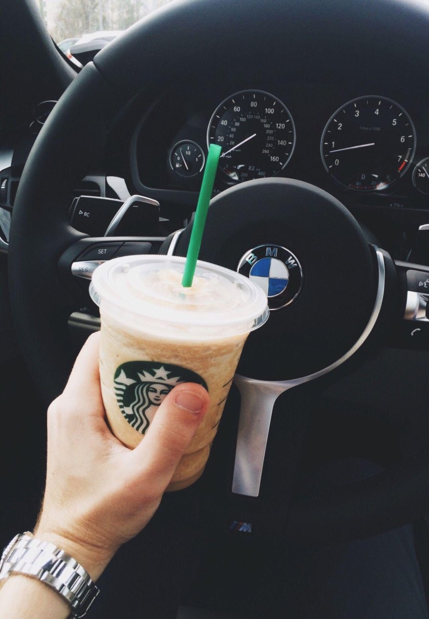 Стакан кофе в руке в машине