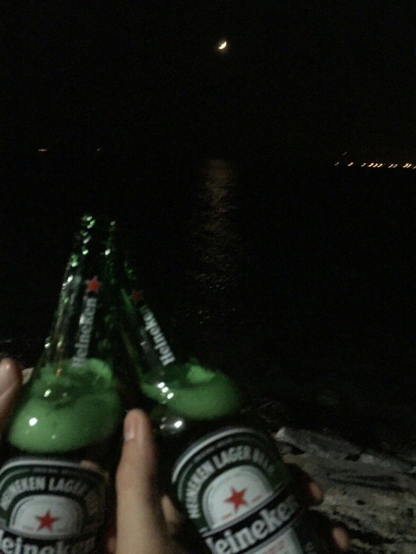 Бутылка пива в руке ночью