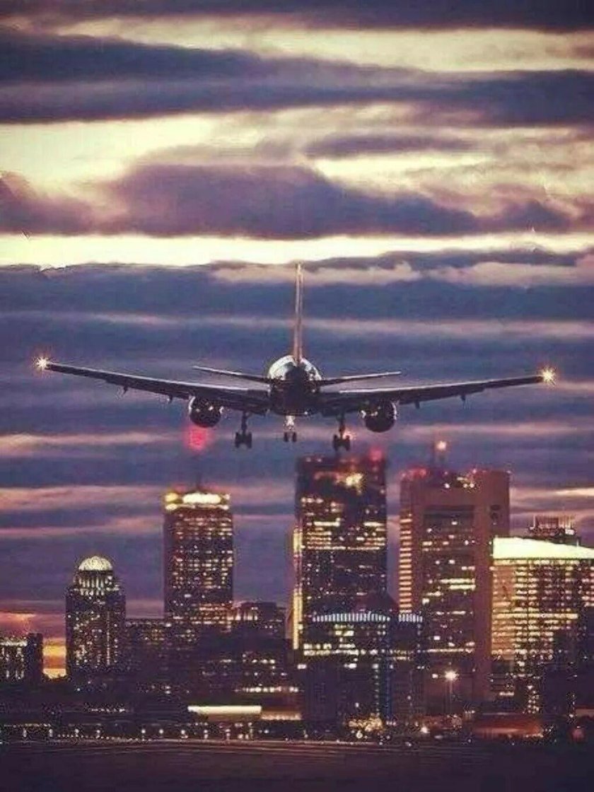 Самолет на закате над городом