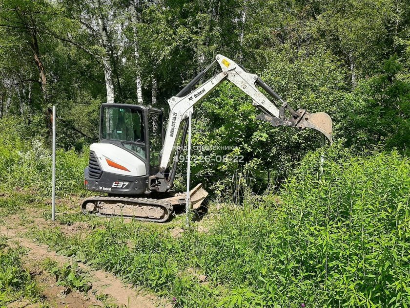 Экскаватор у забора